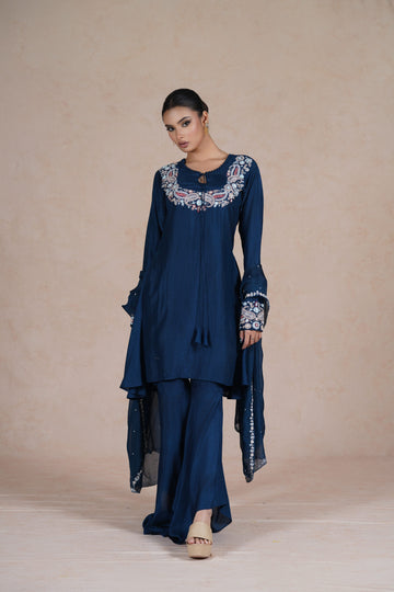 model wearing a royal blue embroidered suit with a round neckline, full sleeves, and a matching dupatta.