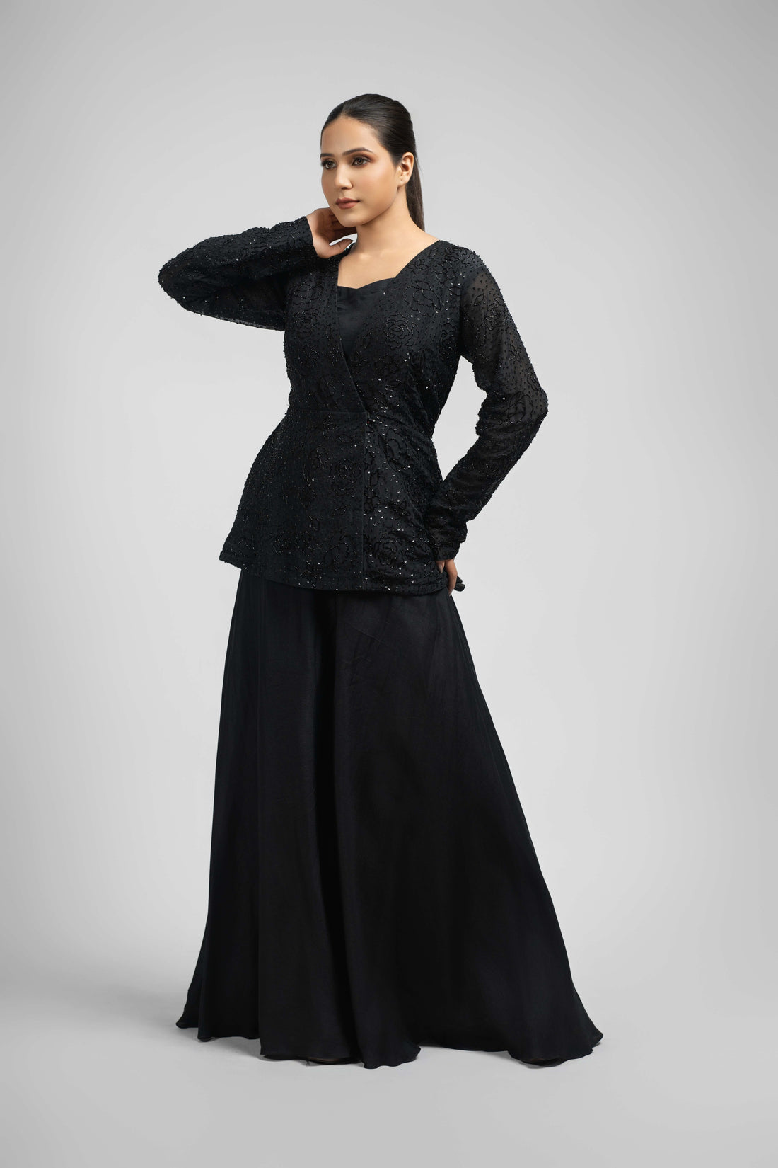 Black Indowestern outfit featuring a pearl and sequin-embellished angrakha jacket with full sleeves, paired with umbrella-style silk palazzo pants – modern festive wear.