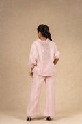 Blush pink textured linen coord set featuring a button-down shirt with puffed sleeves and wide-leg pants, offering a comfortable and stylish look for casual outings.