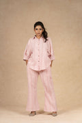 Blush pink textured linen coord set featuring a button-down shirt with puffed sleeves and wide-leg pants, offering a comfortable and stylish look for casual outings.