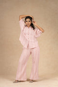 Blush pink textured linen coord set featuring a button-down shirt with puffed sleeves and wide-leg pants, offering a comfortable and stylish look for casual outings.