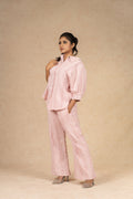 Blush pink textured linen coord set featuring a button-down shirt with puffed sleeves and wide-leg pants, offering a comfortable and stylish look for casual outings.