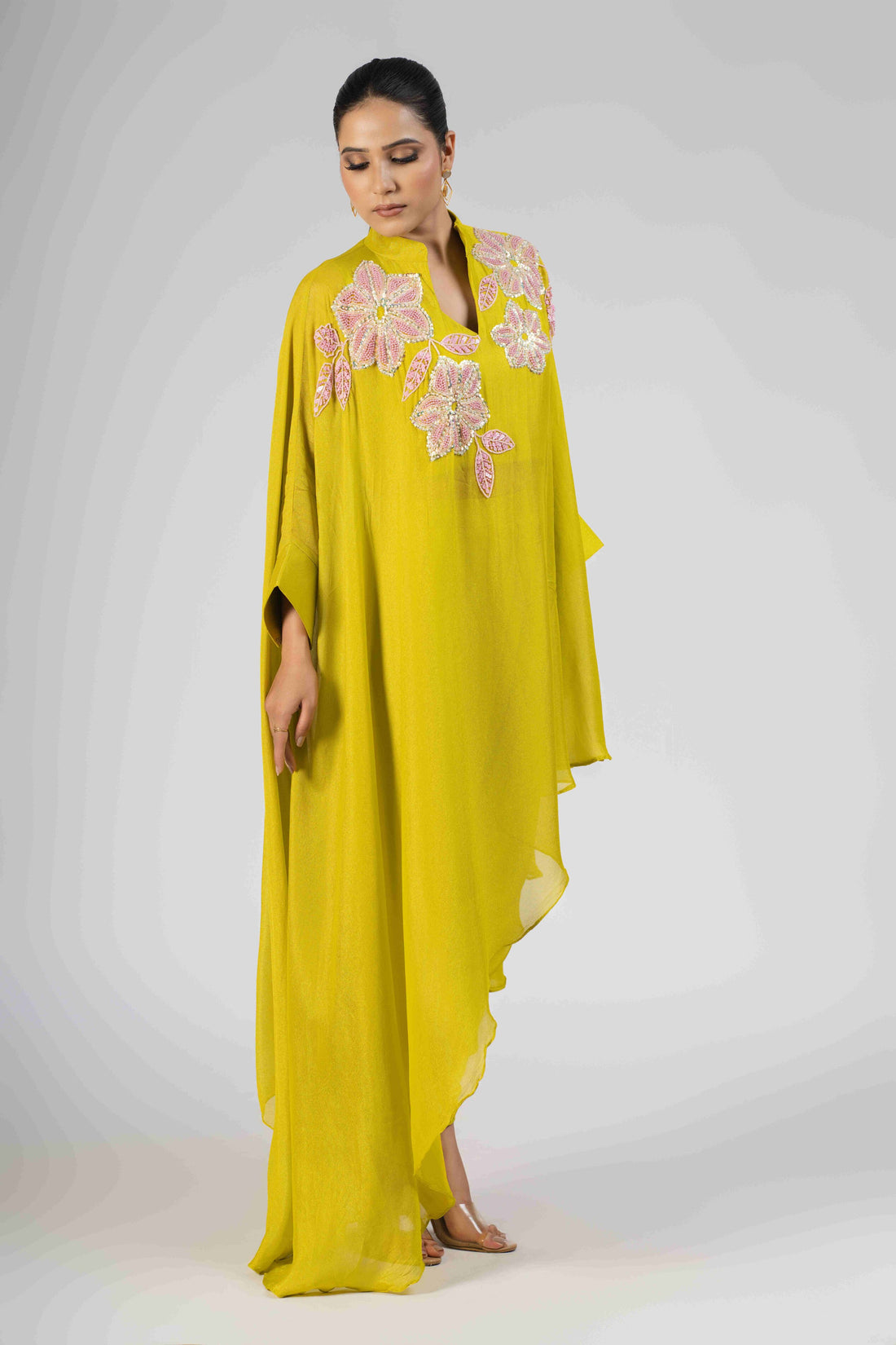 Lime green chinnon cape-style Indo-Western set with floral embellishments, featuring sequins, pearls, and cutdana, paired with matching tulip pants—perfect for festive and formal occasions.