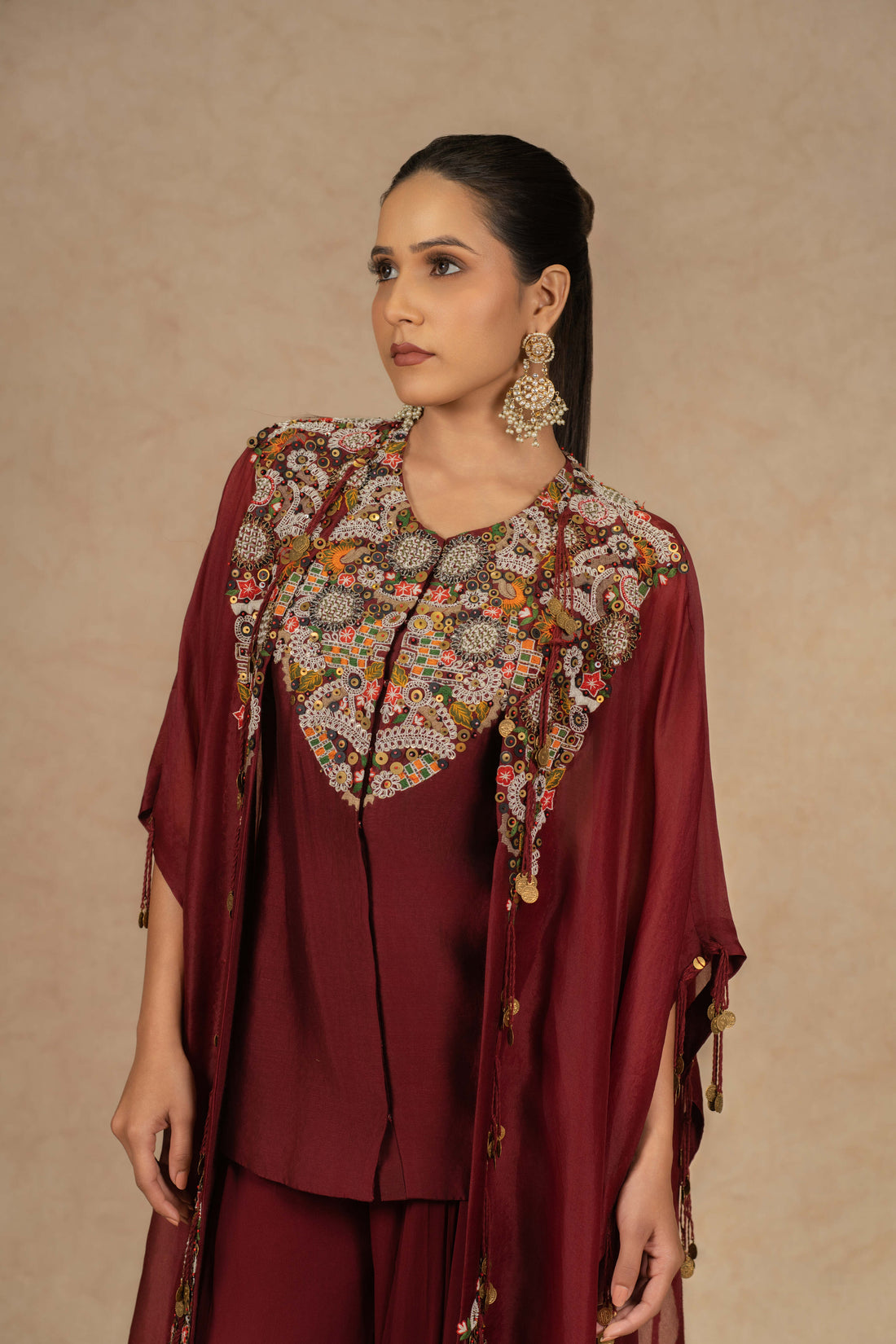 Maroon organza Indo-Western kurta set with intricate Dori, sequins, pearls, and thread embellishments, paired with matching flowy palazzo pants, perfect for festive and formal occasions.