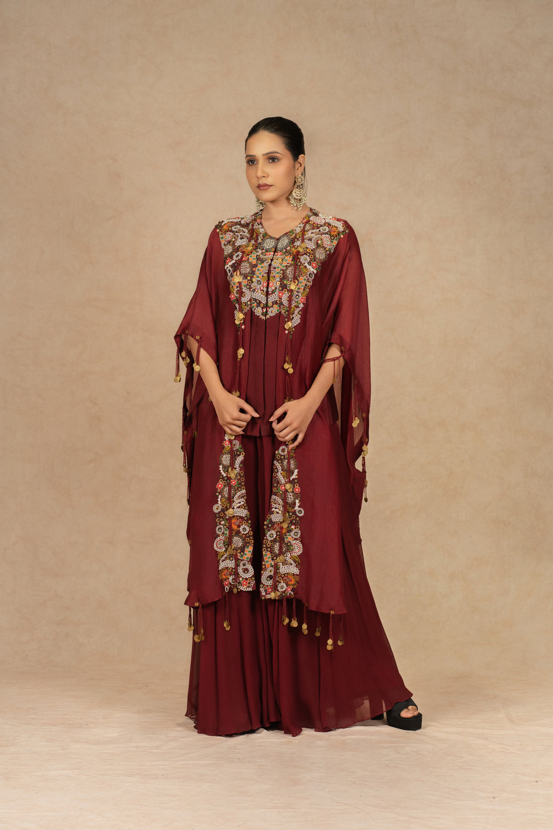 Maroon organza Indo-Western kurta set with intricate Dori, sequins, pearls, and thread embellishments, paired with matching flowy palazzo pants, perfect for festive and formal occasions.