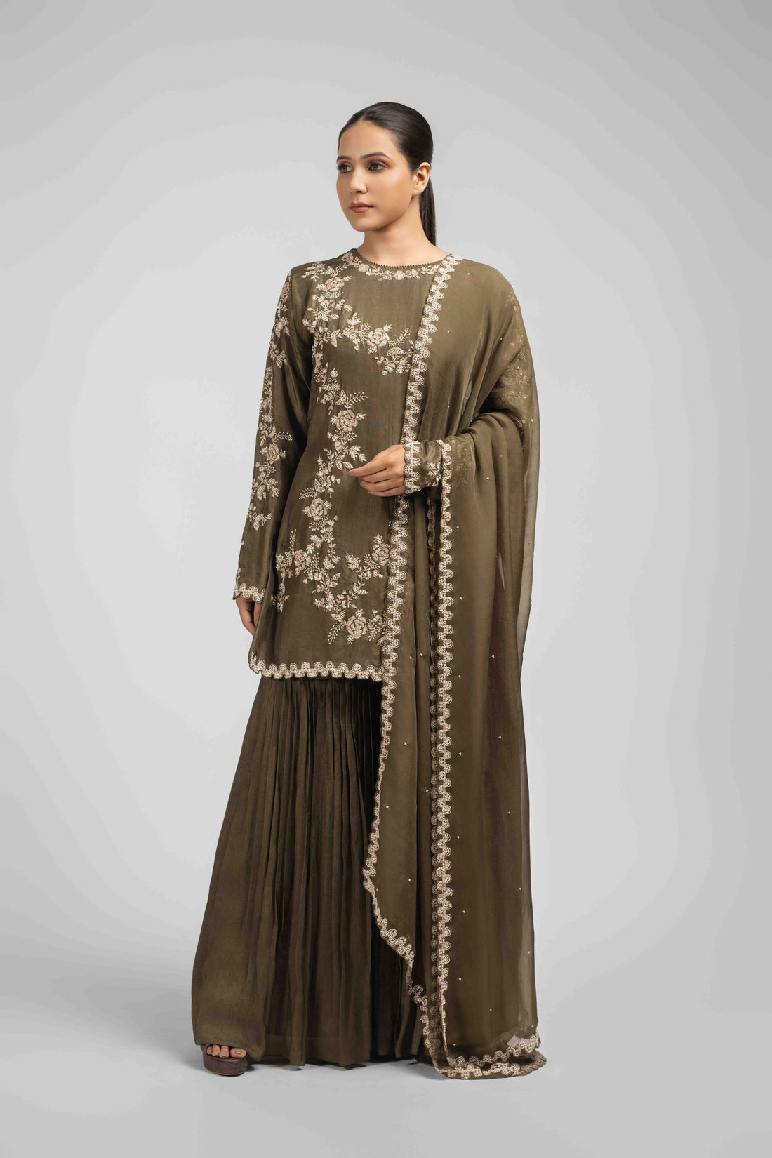 Mehendi green sharara suit with an embellished kurta featuring pearls, sequins, zardozi, kasab, and pitai work, paired with pleated sharara pants and an organza dupatta for an elegant festive look.
