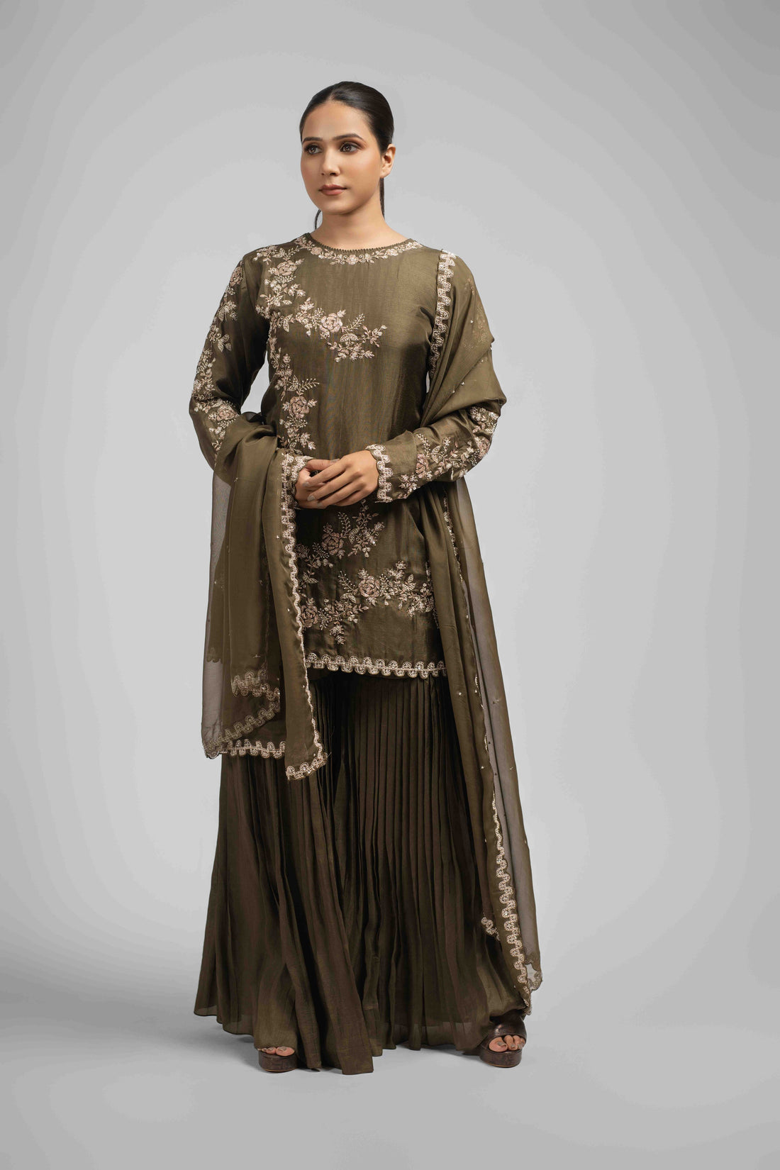 Mehendi green sharara suit with an embellished kurta featuring pearls, sequins, zardozi, kasab, and pitai work, paired with pleated sharara pants and an organza dupatta for an elegant festive look.