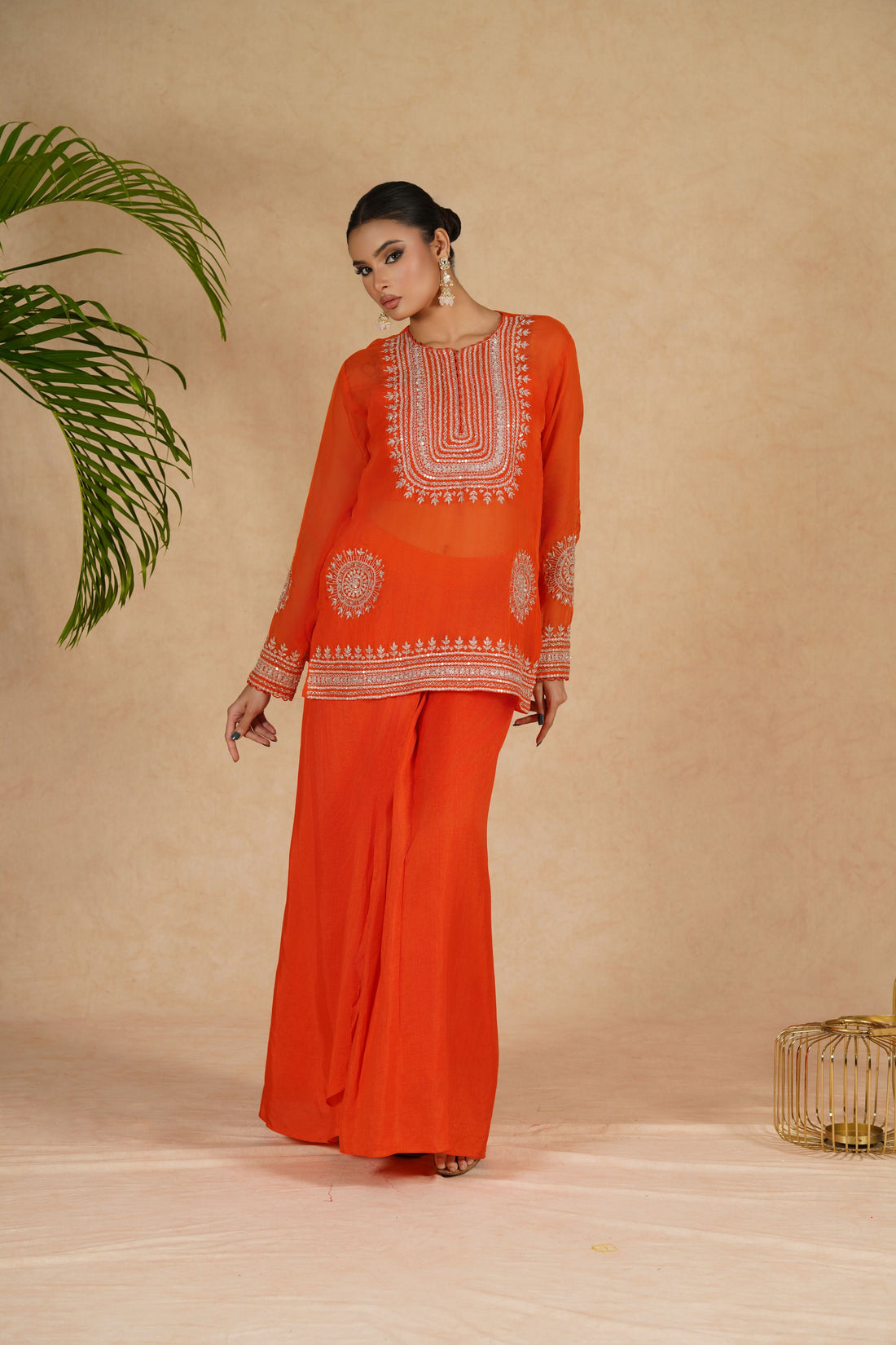 Elegant Orange Organza Indowestern outfit featuring a beautifully embroidered crop top with pearl, kasab, sequins, zardozi, and pitai work, paired with a flowing drape skirt – perfect for festive and wedding wear.