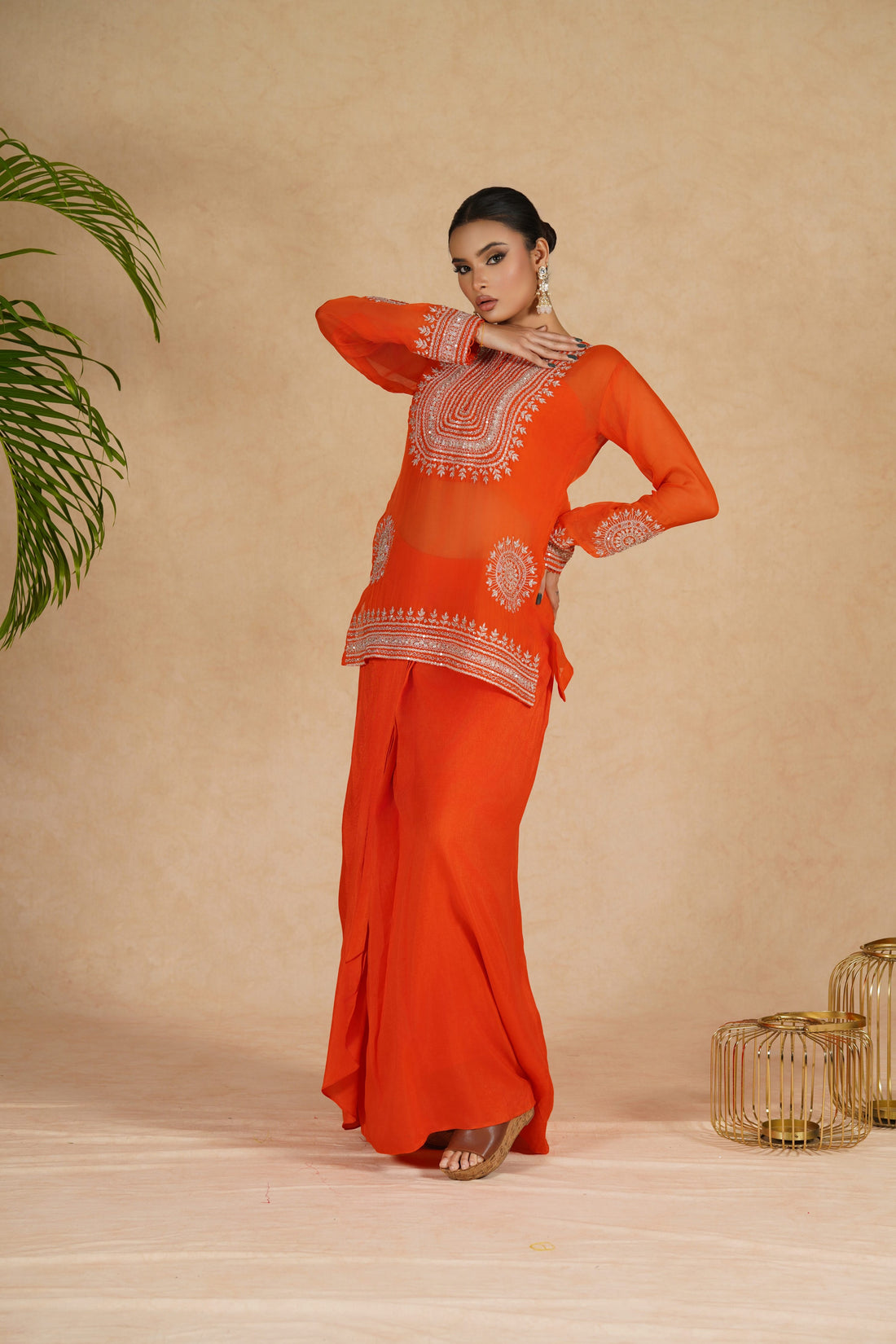 Elegant Orange Organza Indowestern outfit featuring a beautifully embroidered crop top with pearl, kasab, sequins, zardozi, and pitai work, paired with a flowing drape skirt – perfect for festive and wedding wear.