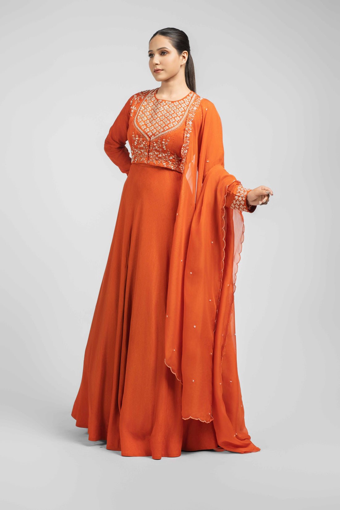Orange silk double-layer gown with embellished bodice and cuffs, paired with an organza dupatta featuring kasab, zardozi, sequins, and pitai work – perfect for festive and wedding wear.