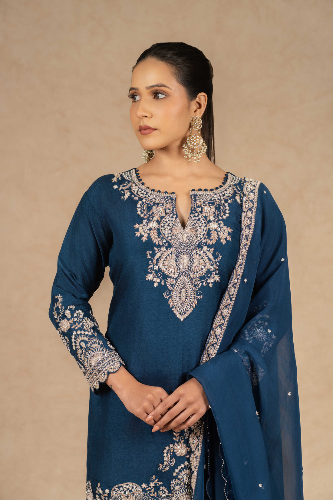 Peacock blue embroidered sharara suit with silk kurta, pleated sharara, and organza dupatta featuring intricate dabka, kasab, sequins, and pearl embellishments – perfect for festive and wedding occasions.