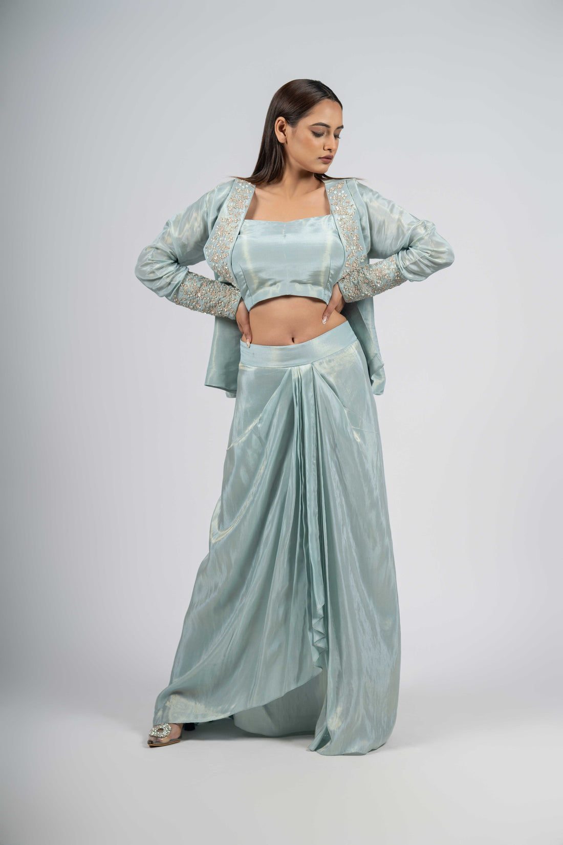 Powder blue indo-western set featuring an embellished lapel collar blazer, sleeveless blouse, and dhoti pleated skirt with intricate pearl, kasab, sequin, and zardozi embellishments. Ideal for festive and formal occasions.