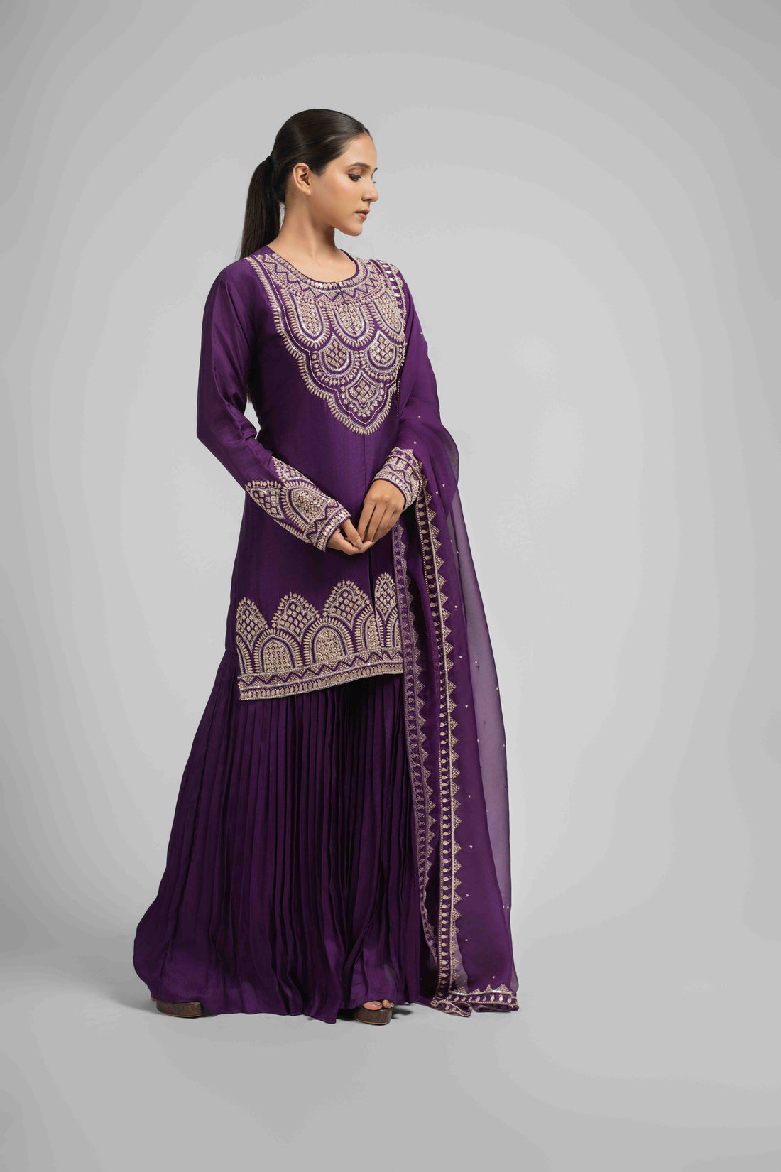 Purple embroidered silk sharara suit with organza dupatta, featuring intricate pearl, sequin, zardozi, kasab, and pitai work, ideal for festive and wedding wear.
