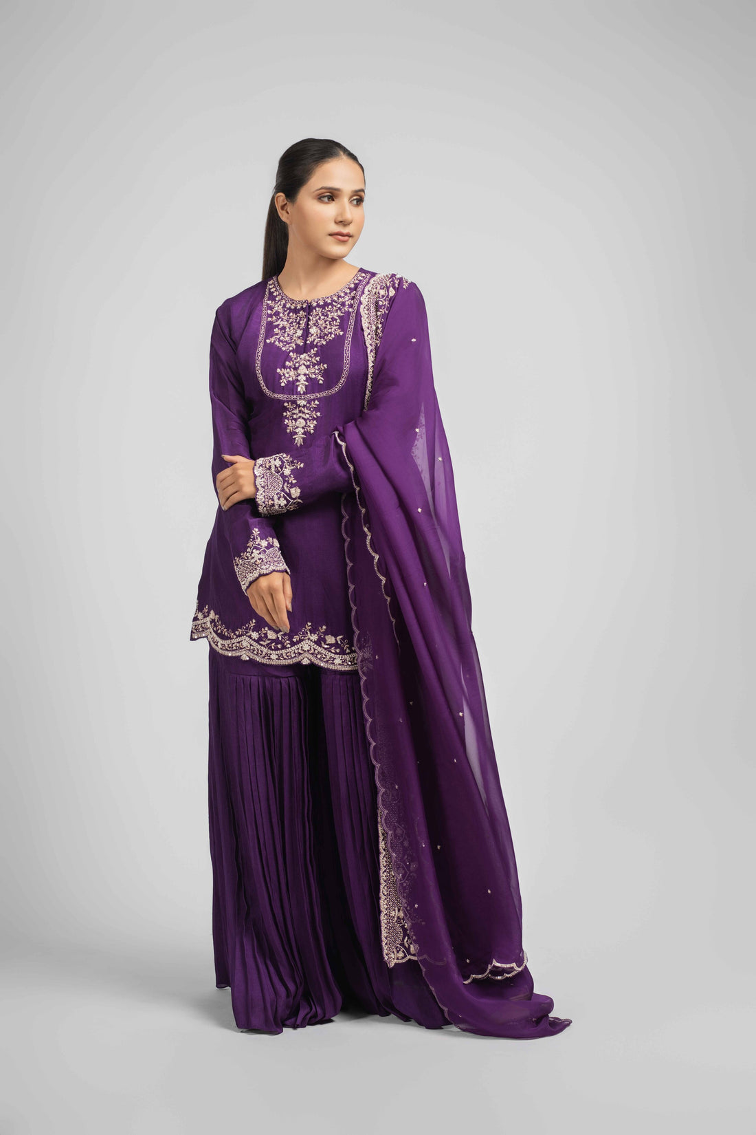 Purple silk sharara set featuring an embroidered kurta with pearl, gotta patti, sequins, zardozi, kasab, and pitai work, paired with pleated sharara pants and an embellished organza dupatta, perfect for festive and wedding occasions.