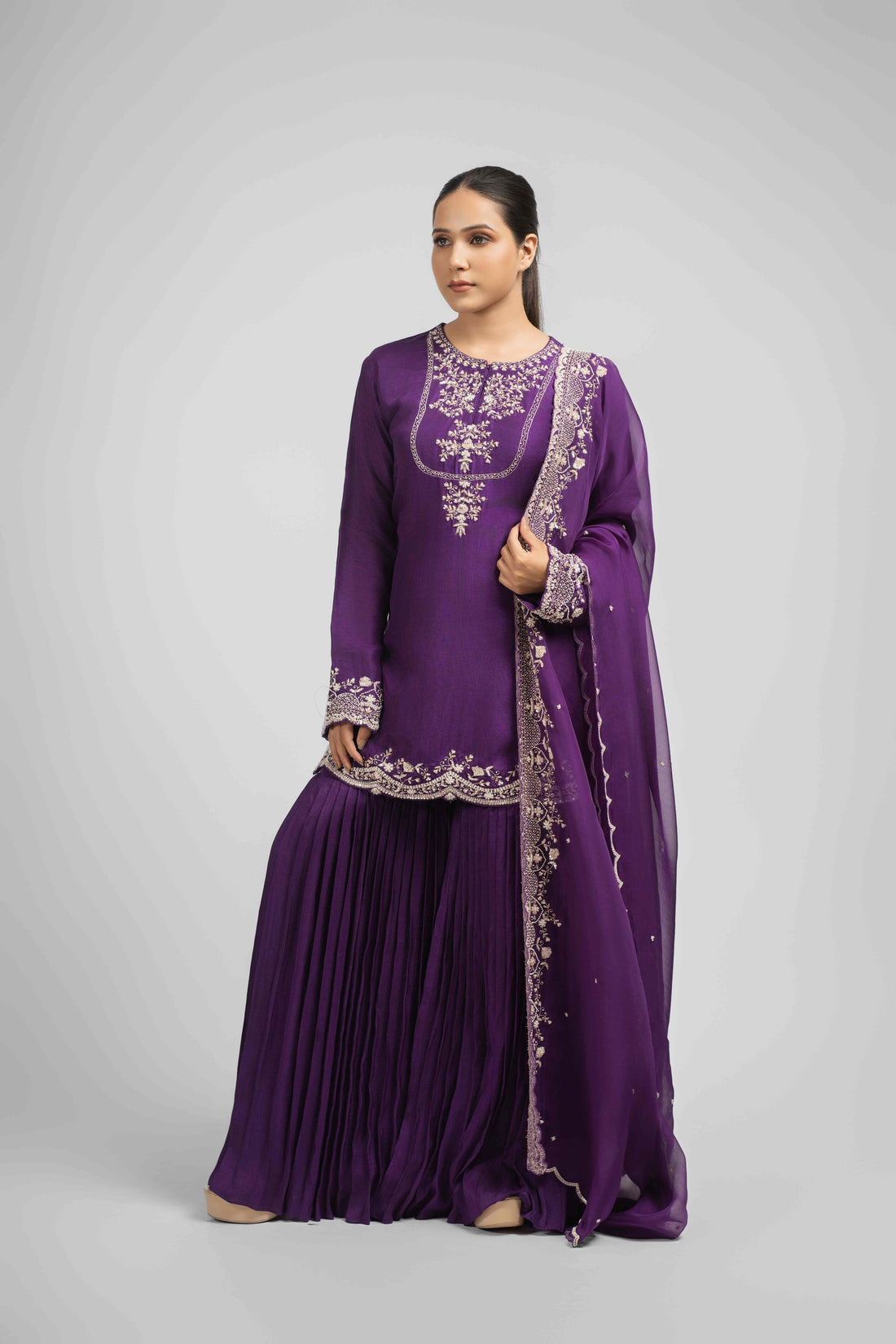 Purple silk sharara set featuring an embroidered kurta with pearl, gotta patti, sequins, zardozi, kasab, and pitai work, paired with pleated sharara pants and an embellished organza dupatta, perfect for festive and wedding occasions.