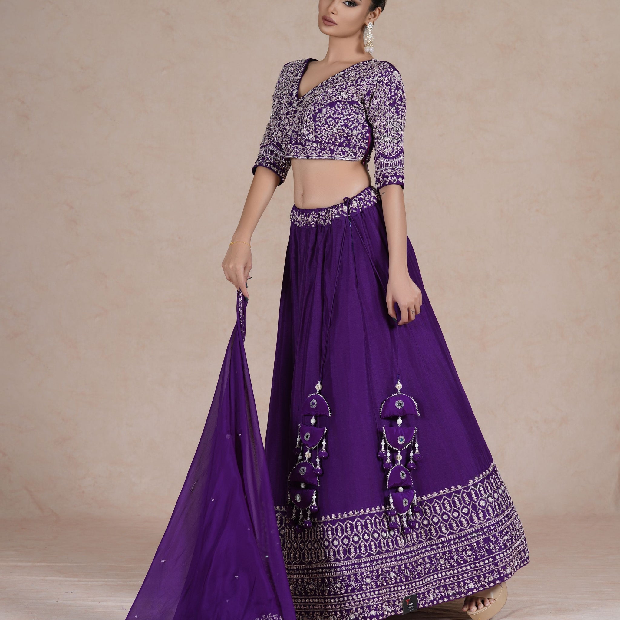 Purple embroidered lehenga choli set with intricate sequin, pearl, kasab, zardozi, and pitai work, paired with an organza dupatta – perfect for festive and wedding occasions.