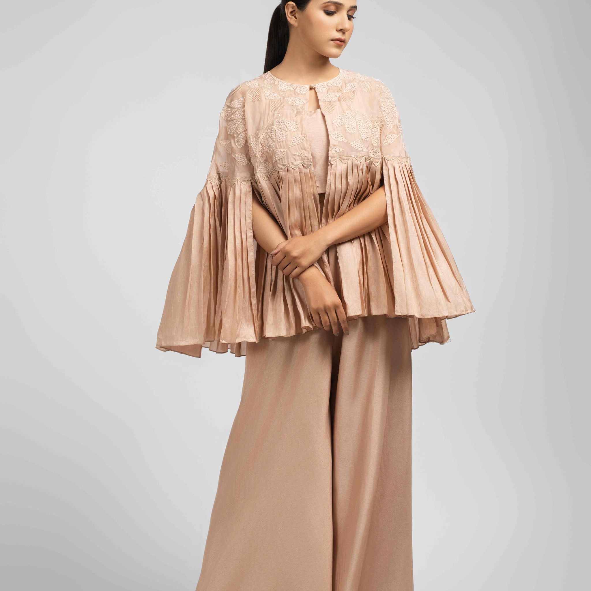 Elegant Ash Rose Pink Indo Western Set featuring a pleated jacket, sleeveless crop top, and flared palazzo.
