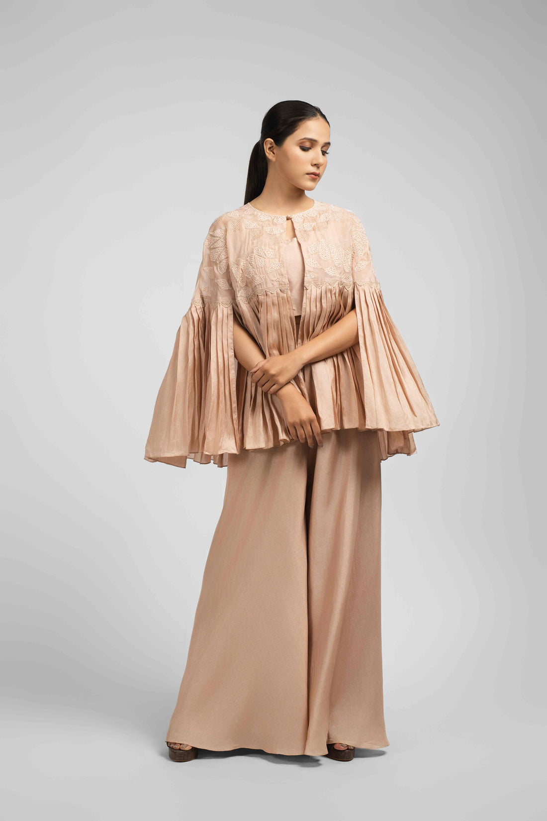 Elegant Ash Rose Pink Indo Western Set featuring a pleated jacket, sleeveless crop top, and flared palazzo.
