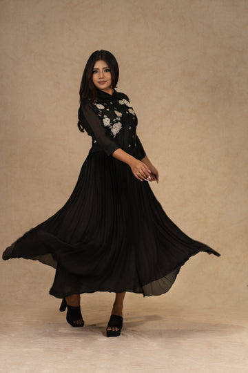 A black organza pleated shirt dress featuring applique floral designs and intricate zardozi work, ideal for festive and formal occasions.