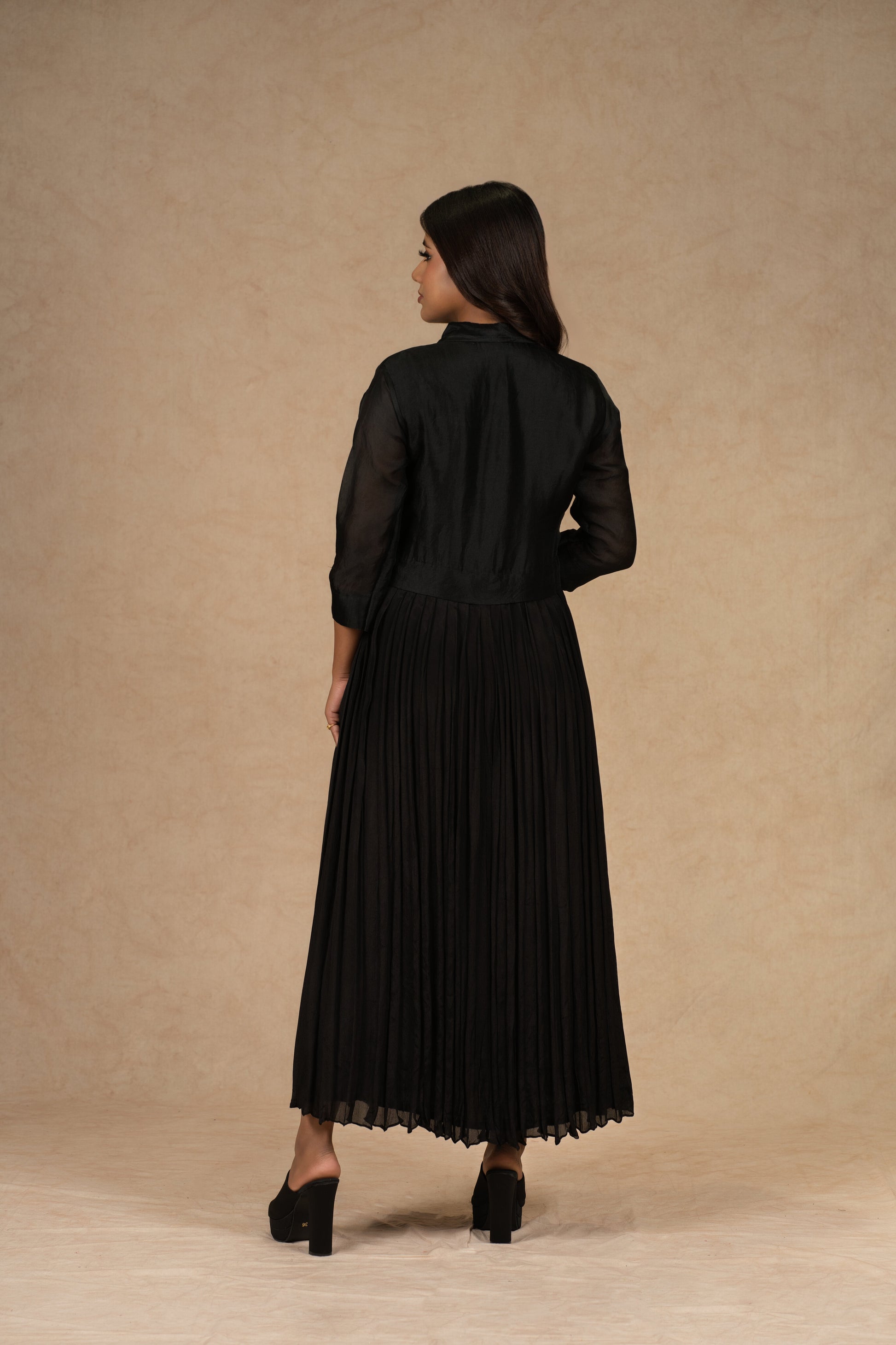 A black organza pleated shirt dress featuring applique floral designs and intricate zardozi work, ideal for festive and formal occasions.