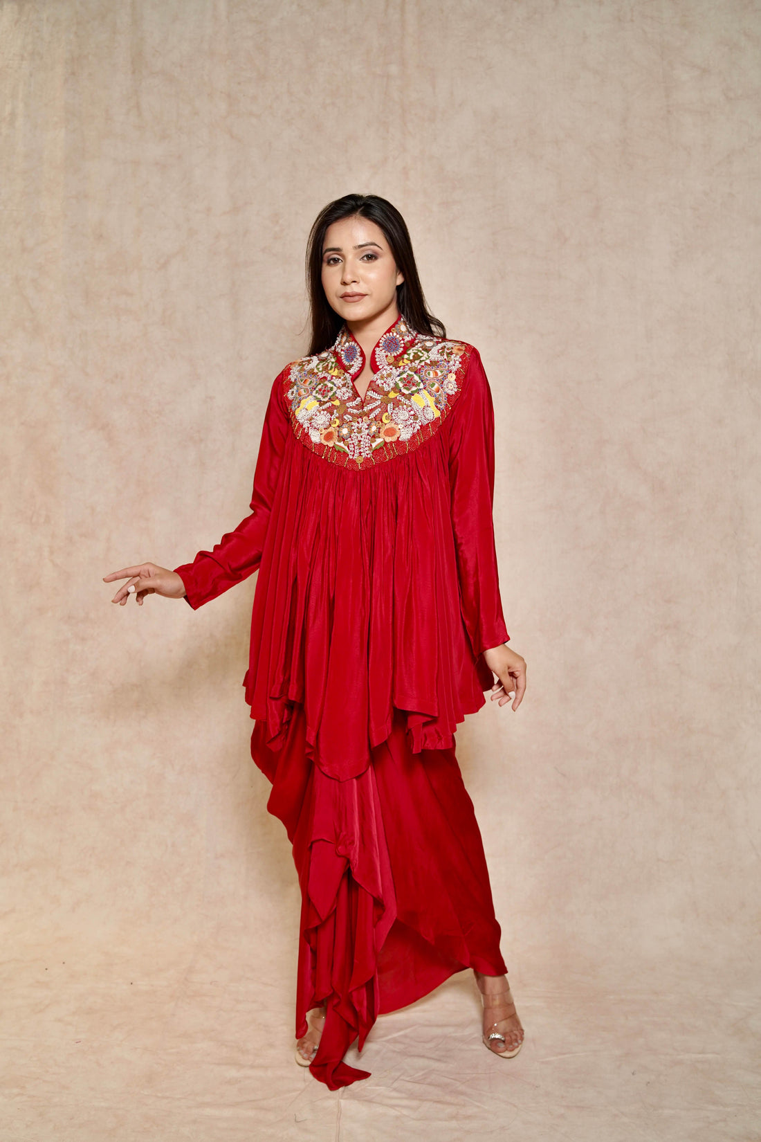 Model wearing a Blood Red Draped Skirt Set featuring an embroidered cape-style tunic with a high collar, perfect for festive occasions.