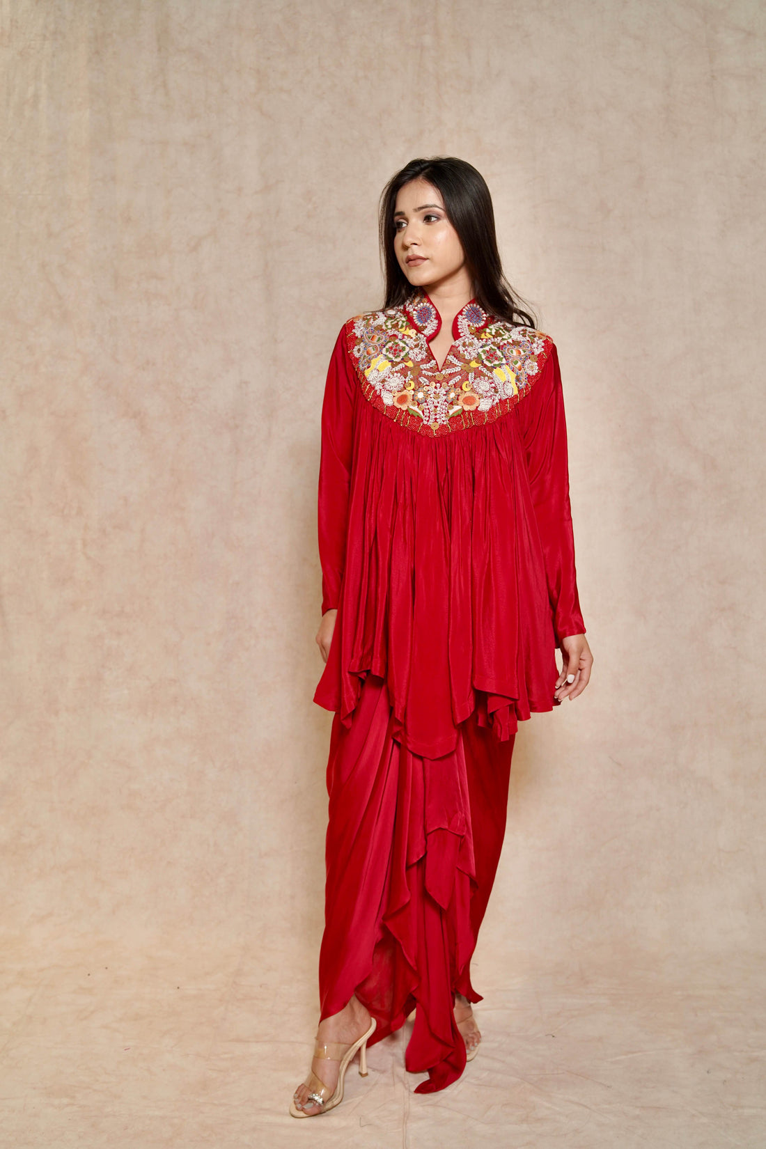 Model wearing a Blood Red Draped Skirt Set featuring an embroidered cape-style tunic with a high collar, perfect for festive occasions.
