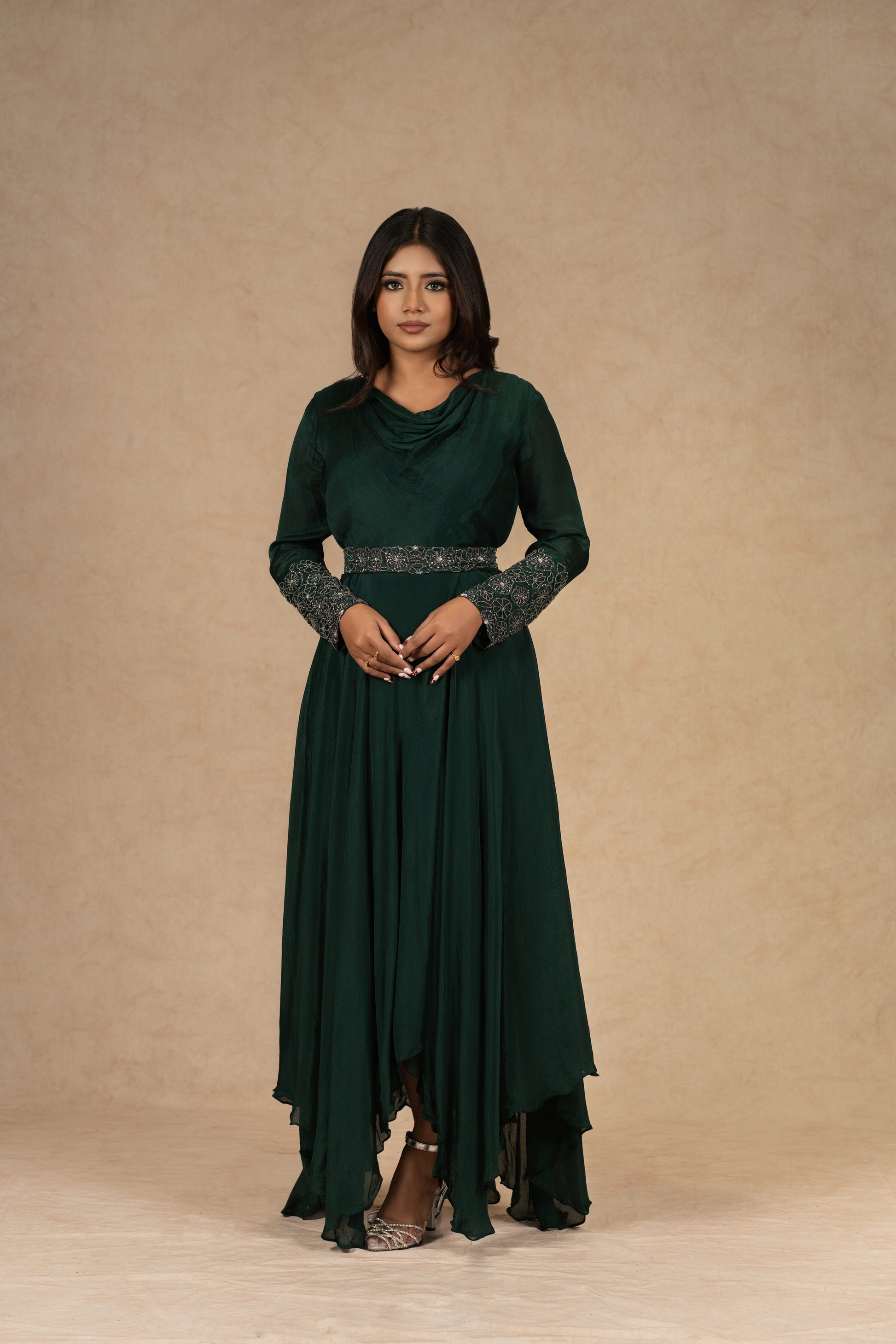 A model wearing a Bottle Green Chinnon Gown with an Ivory Organza Indowestern drape skirt and a bustier, adorned with dori work and pearl embellishments, styled for festive or formal occasions.