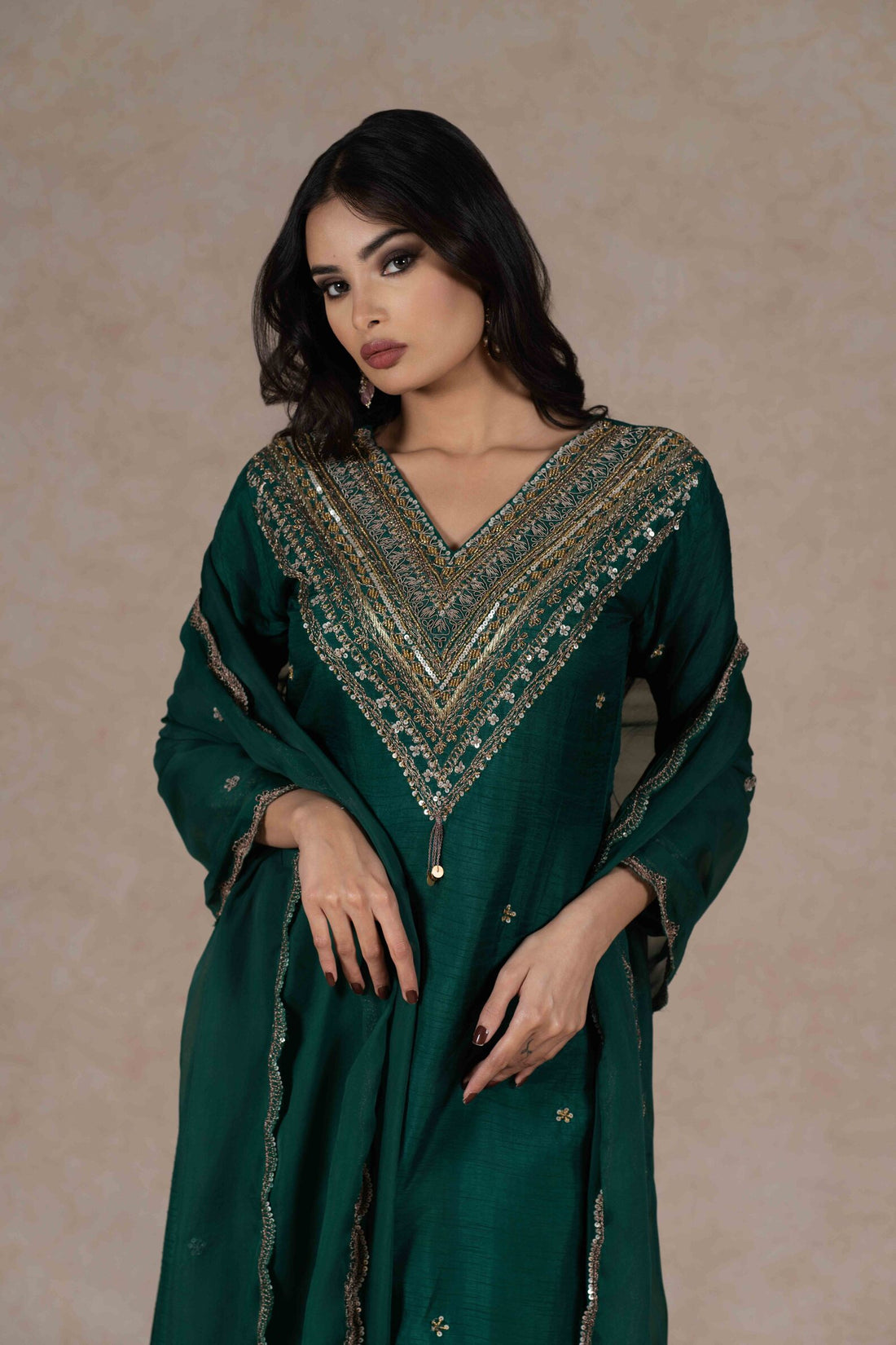 Green embroidered kurta set with a V-neckline, 3/4th sleeves, and gold hand embroidery on the front and dupatta, paired with matching pants.