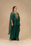 Side-profile view of a model wearing a Bottle Green Organza Indowestern, highlighting the draped skirt, embroidered bodice, and flowy sheer cape.