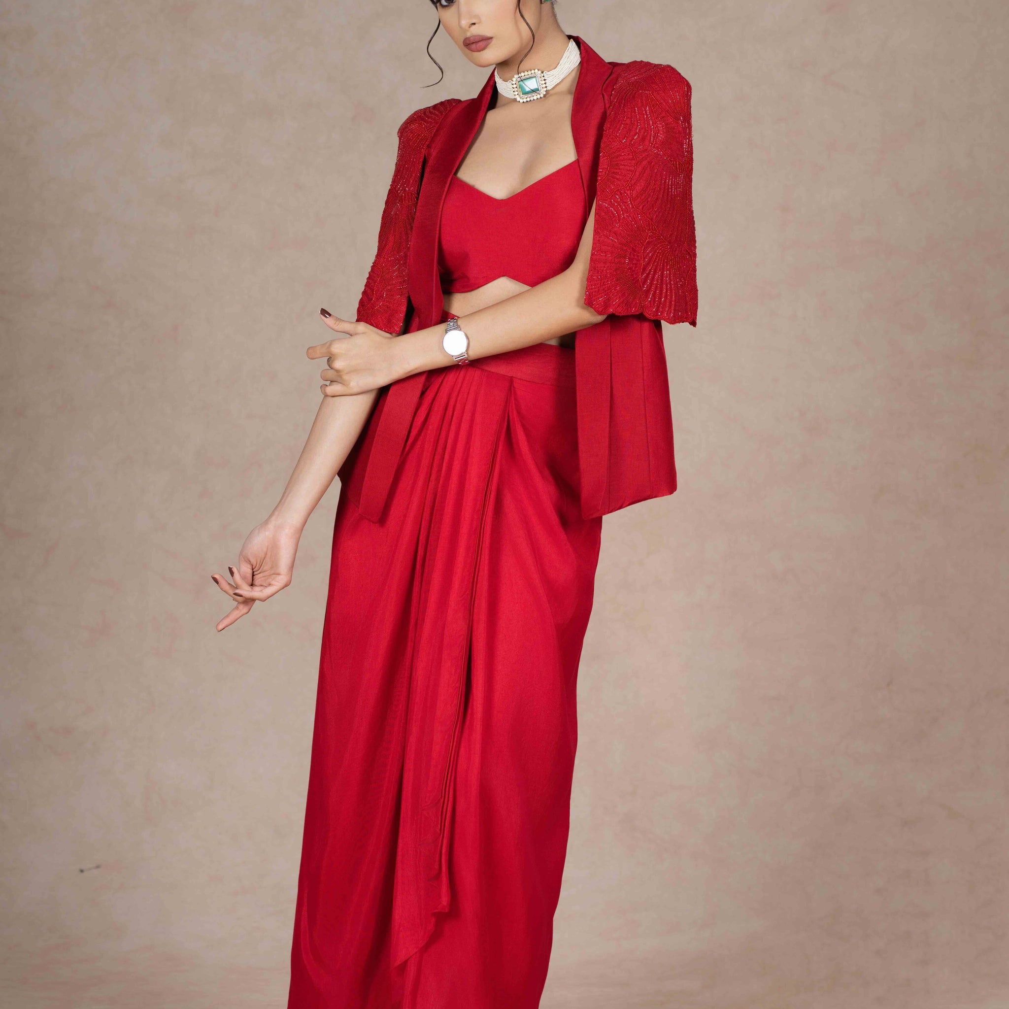 Cherry red jacket, bustier, and pre-draped skirt with hand-beaded cape sleeves. Lightweight, stylish, and perfect for festive, wedding, or formal occasions.