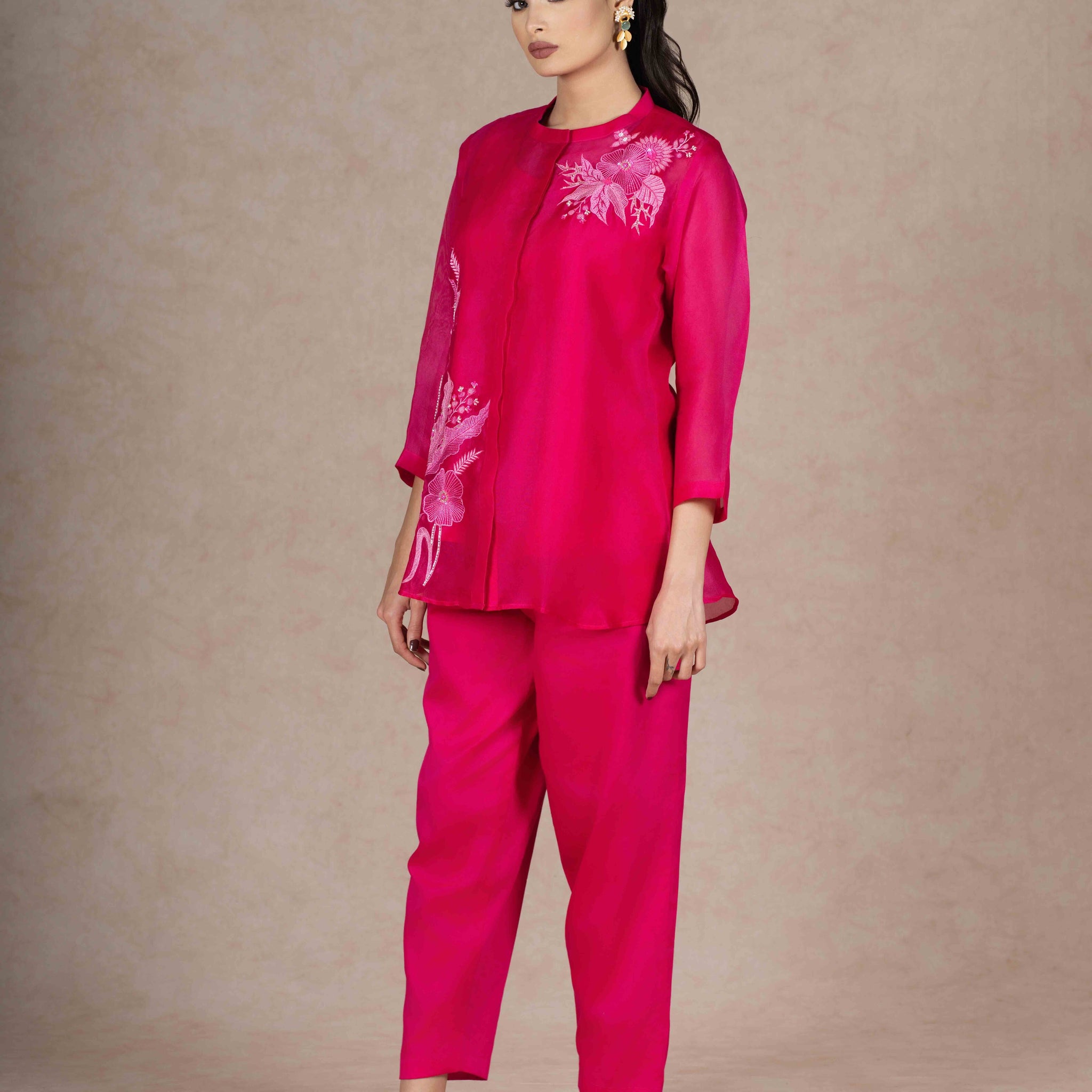 Model wearing a Fuchsia Organza Co-ord Set with floral embroidery, featuring a front-open top with three-quarter sleeves and matching trousers.