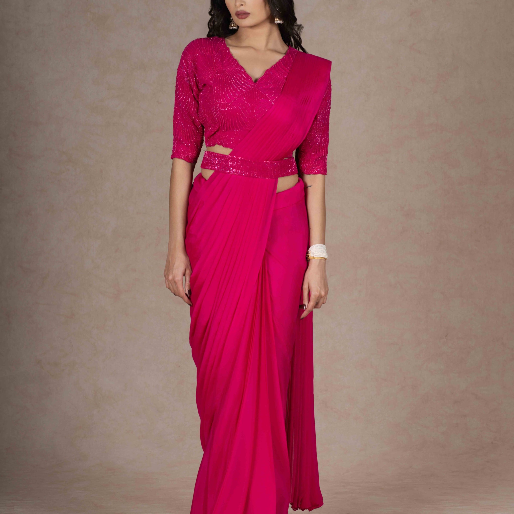 Fuchsia ready-to-wear drape saree with embellished blouse and tie-up belt, crafted in lightweight crepe fabric for a stylish and comfortable festive look.