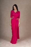 Fuchsia ready-to-wear drape saree with embellished blouse and tie-up belt, crafted in lightweight crepe fabric for a stylish and comfortable festive look.