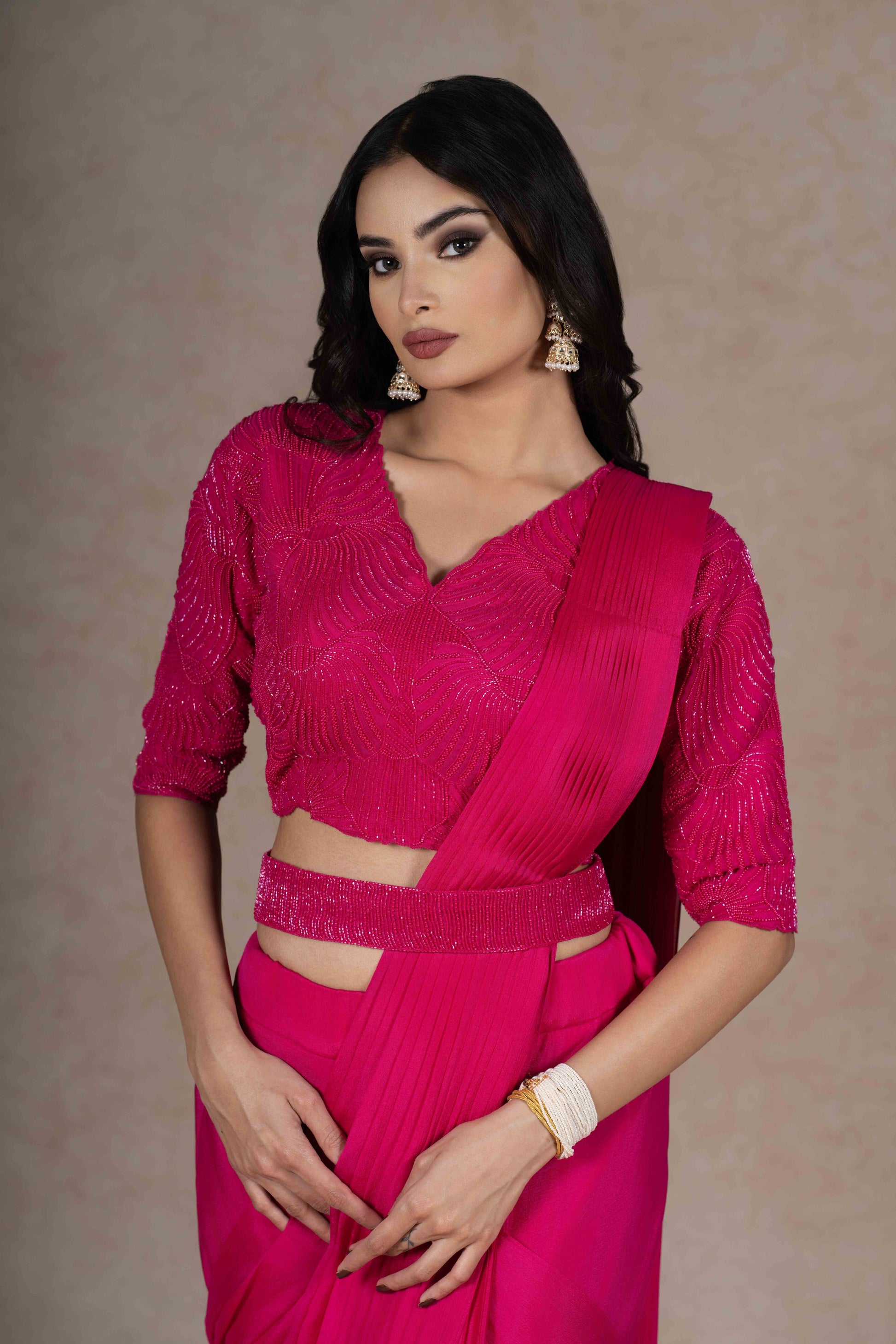 Fuchsia ready-to-wear drape saree with embellished blouse and tie-up belt, crafted in lightweight crepe fabric for a stylish and comfortable festive look.