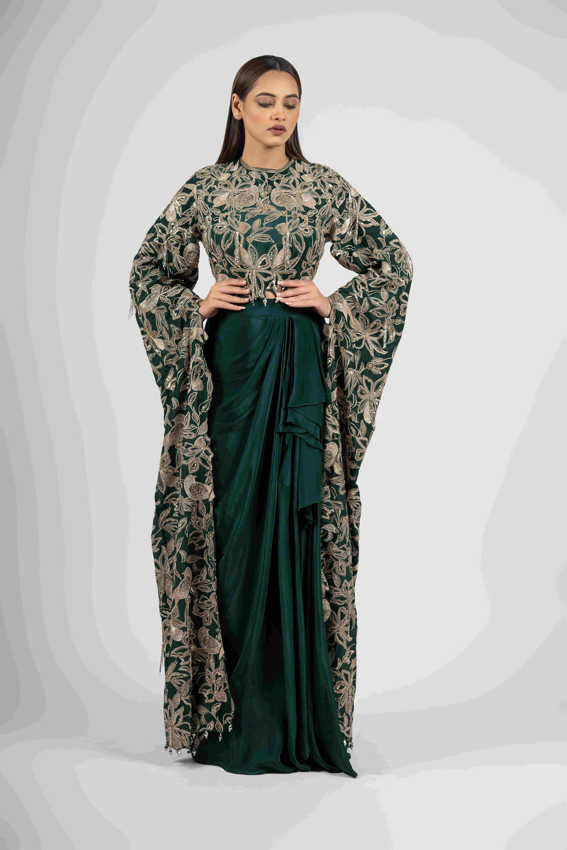 Green crepe crop top with cape sleeves and matching drape skirt embellished with kasab, sequins, thread, and cutdana embroidery – Indo-western festive outfit.