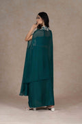 The back view of the outfit showcasing the flowing cape and draped skirt.