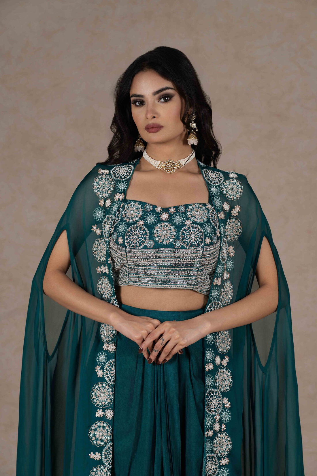 Emerald green three-piece set with an embroidered bustier, a sheer cape with zardozi embroidery, and a draped skirt. A perfect blend of elegance and modern style.