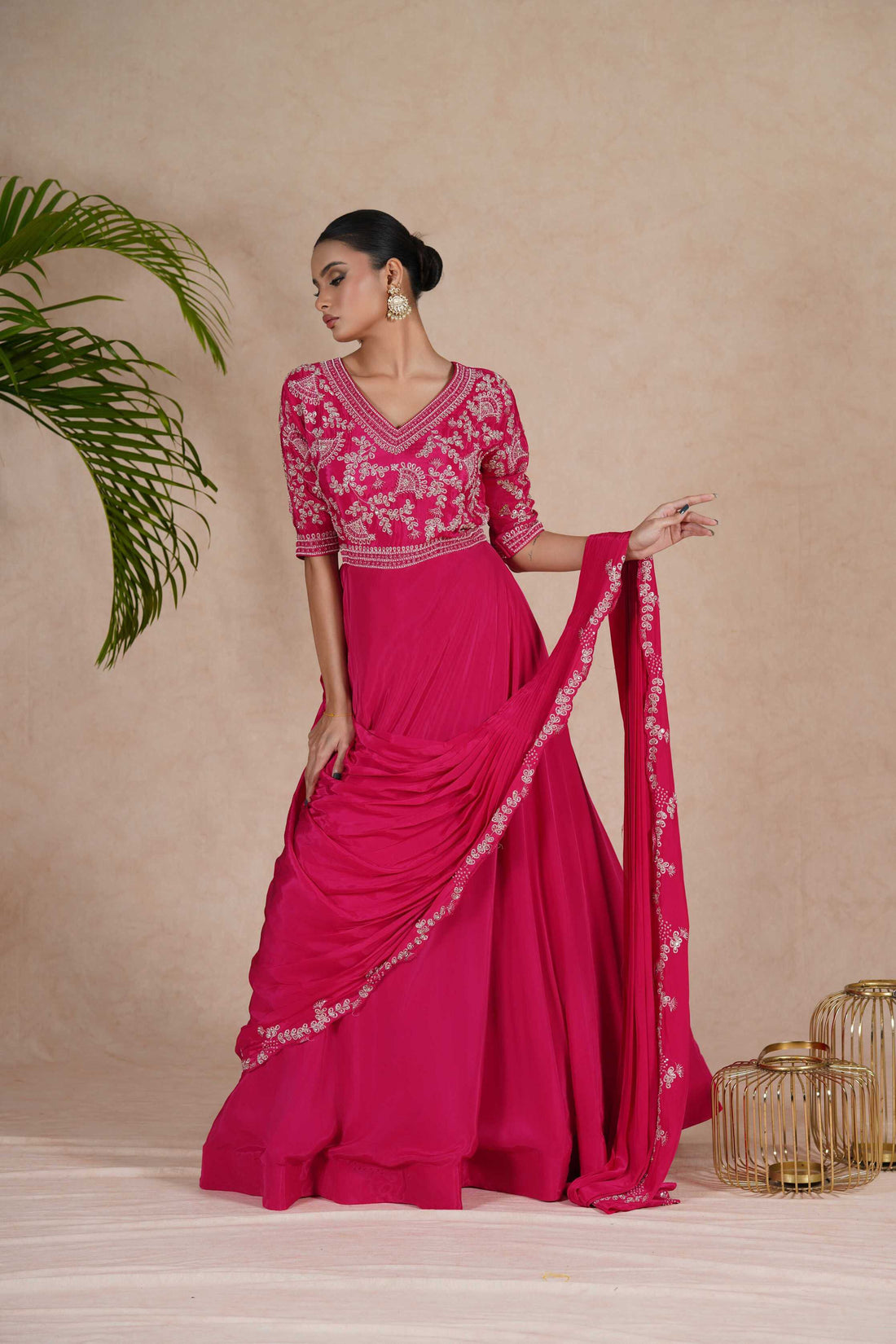 A hot pink embroidered gown with drape, featuring pearl, kasab, zardozi, sequins, and pitai work. Perfect for festive occasions and formal events.