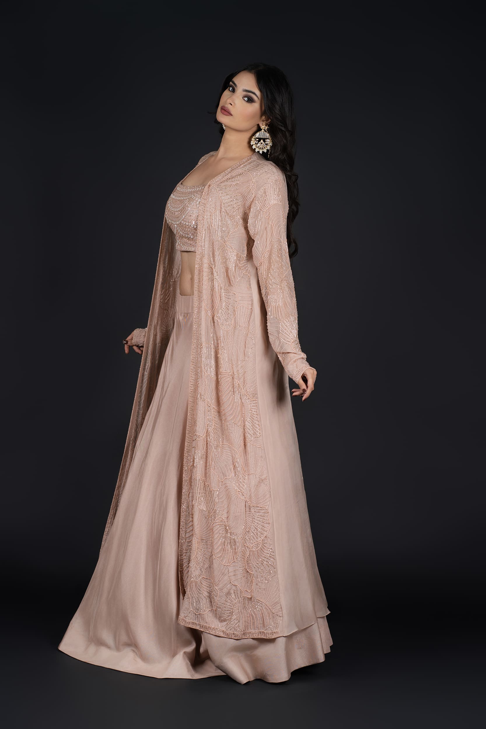 Model in a side pose, flaunting the graceful flow of the Indo-Western Skirt with a long embroidered jacket.