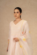 Light peach Chanderi suit with pants and an organza dupatta featuring floral embroidery, pearl embellishments, and pleated detailing, perfect for festive and formal occasions.