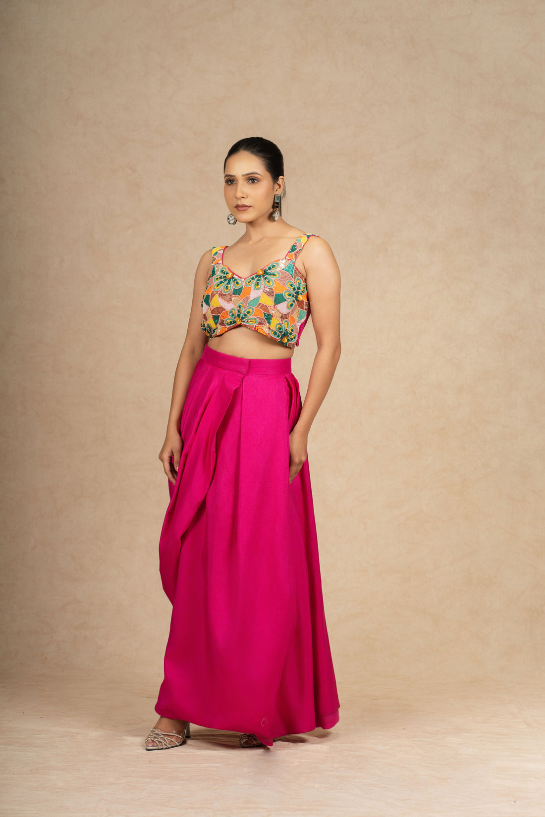 Hot Pink Indowestern set featuring a structured skirt and a crop top with multi-colored sequin and pearl embellishments, ideal for festive and wedding wear.