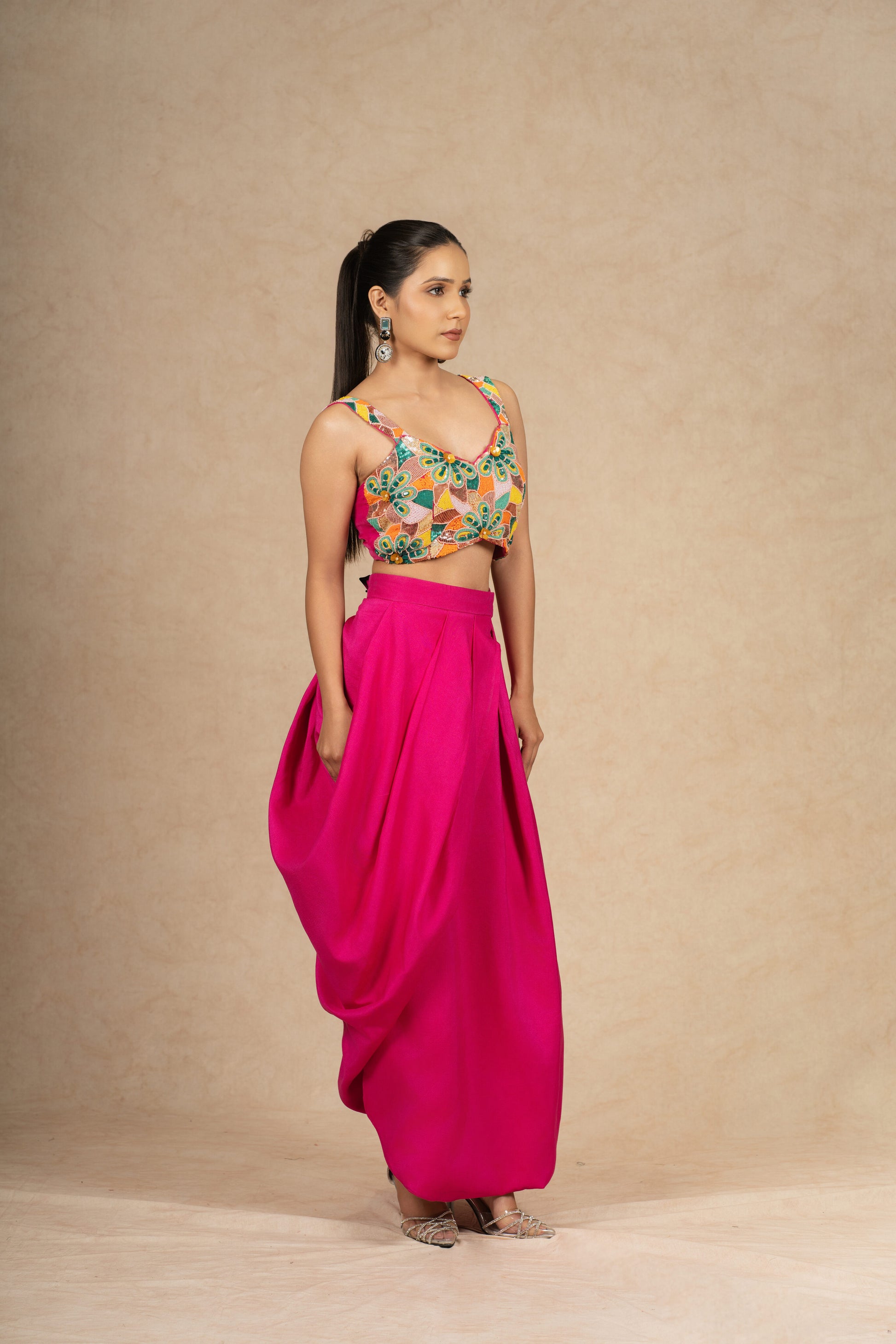 Hot Pink Indowestern set featuring a structured skirt and a crop top with multi-colored sequin and pearl embellishments, ideal for festive and wedding wear.