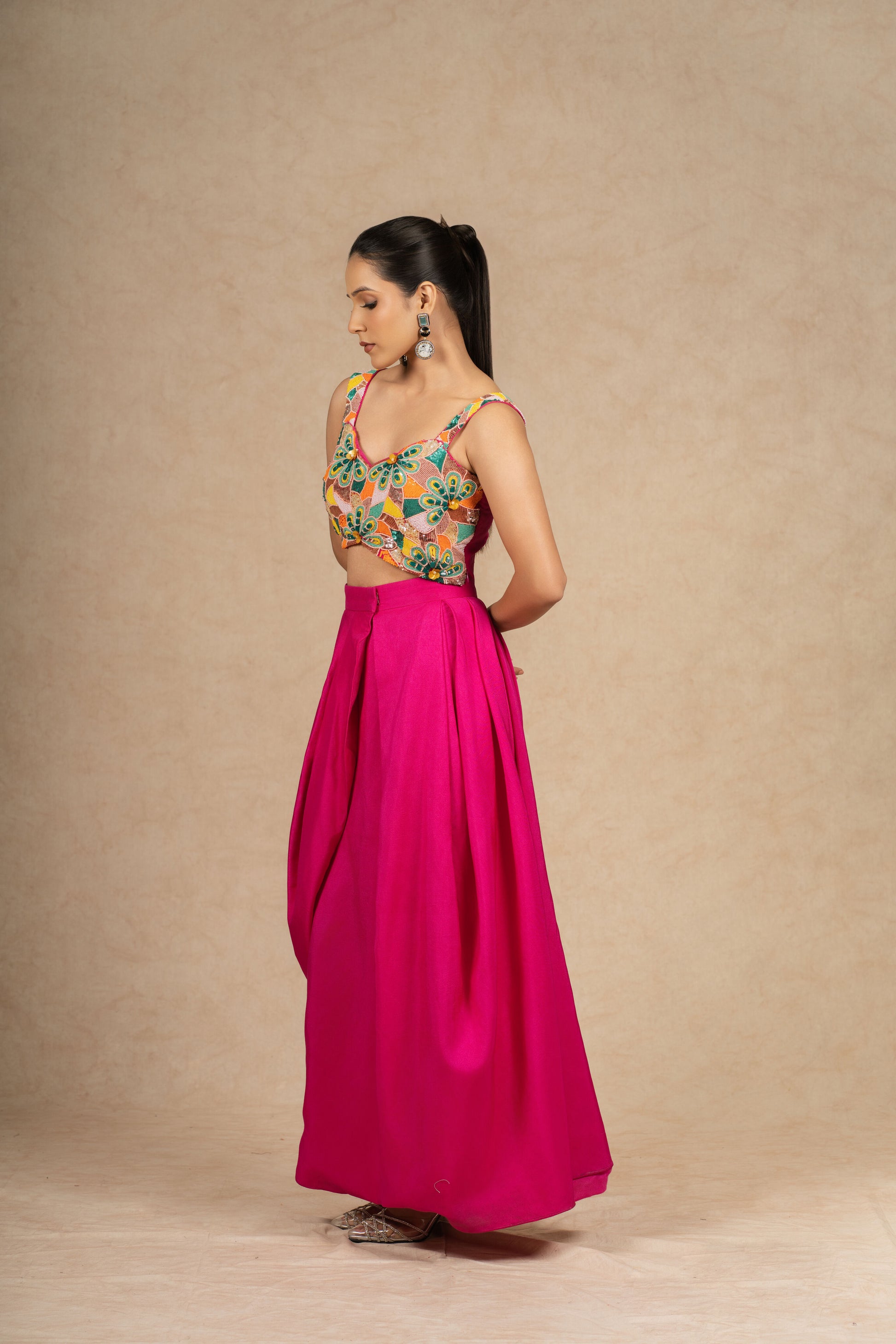 Hot Pink Indowestern set featuring a structured skirt and a crop top with multi-colored sequin and pearl embellishments, ideal for festive and wedding wear.