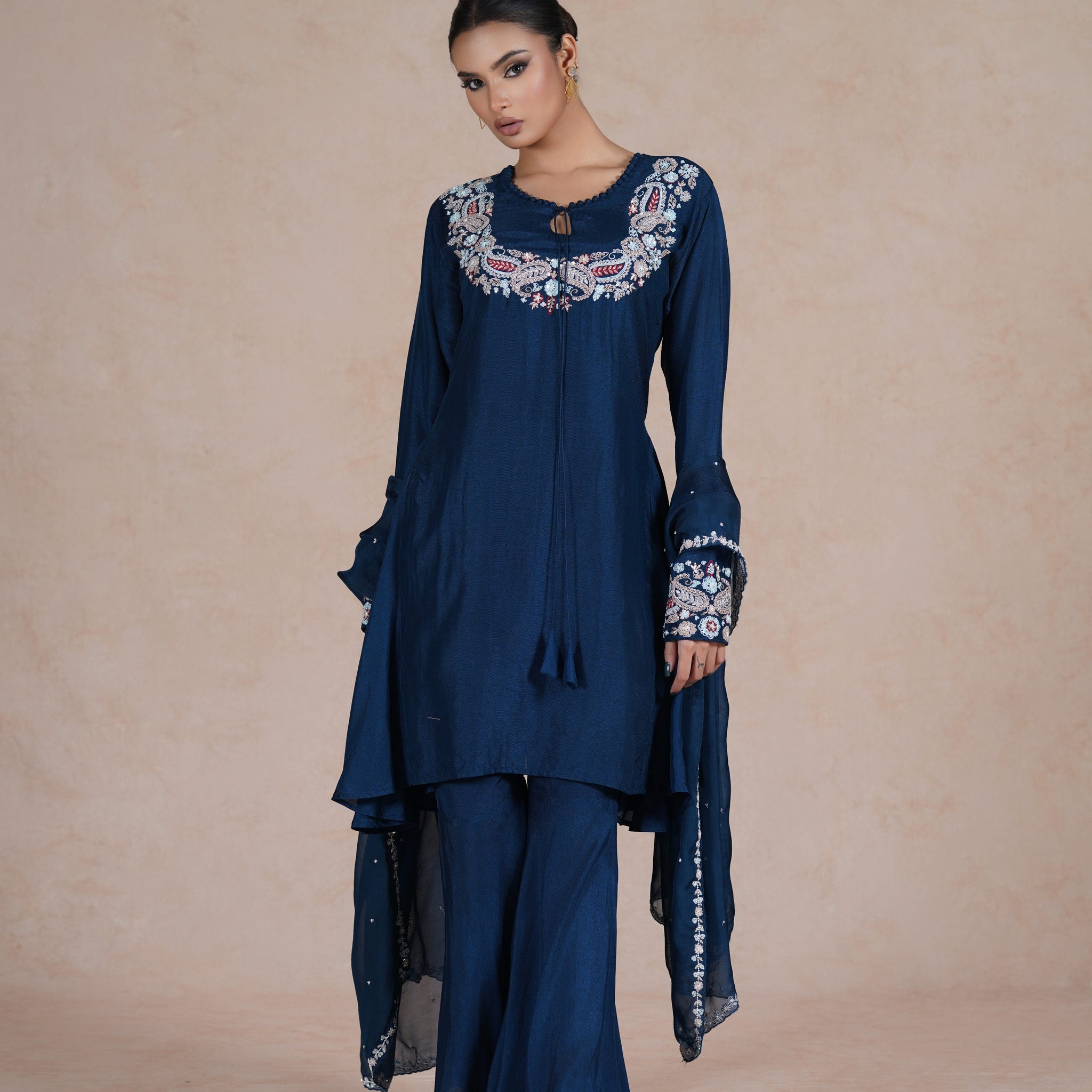  model wearing a royal blue embroidered suit with a round neckline, full sleeves, and a matching dupatta.