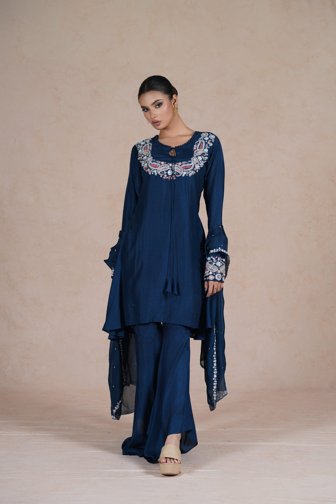  model wearing a royal blue embroidered suit with a round neckline, full sleeves, and a matching dupatta.