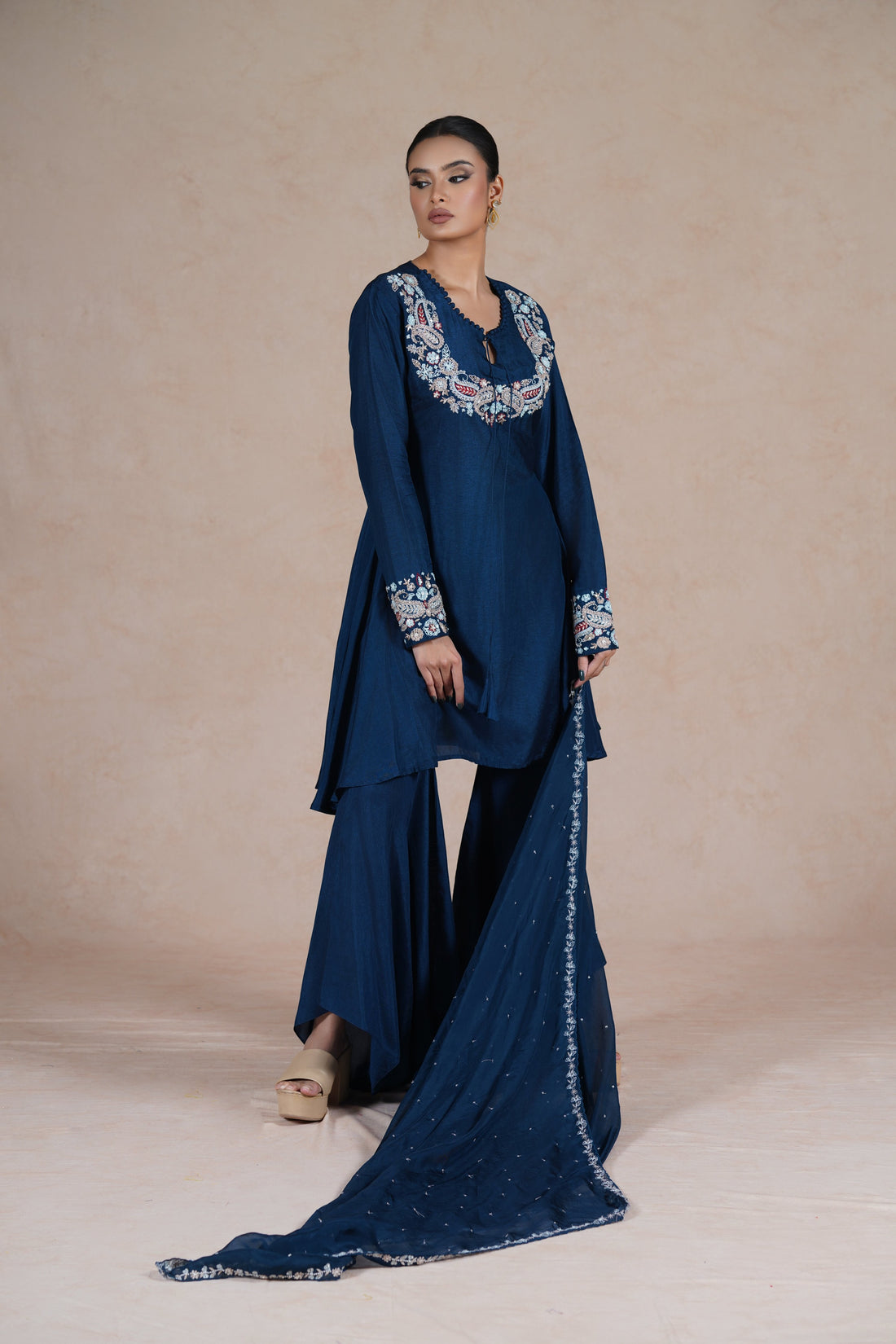  model wearing a royal blue embroidered suit with a round neckline, full sleeves, and a matching dupatta.