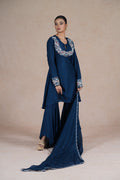 A side view of a model in a royal blue embroidered suit with flared pants and a long, flowing dupatta.