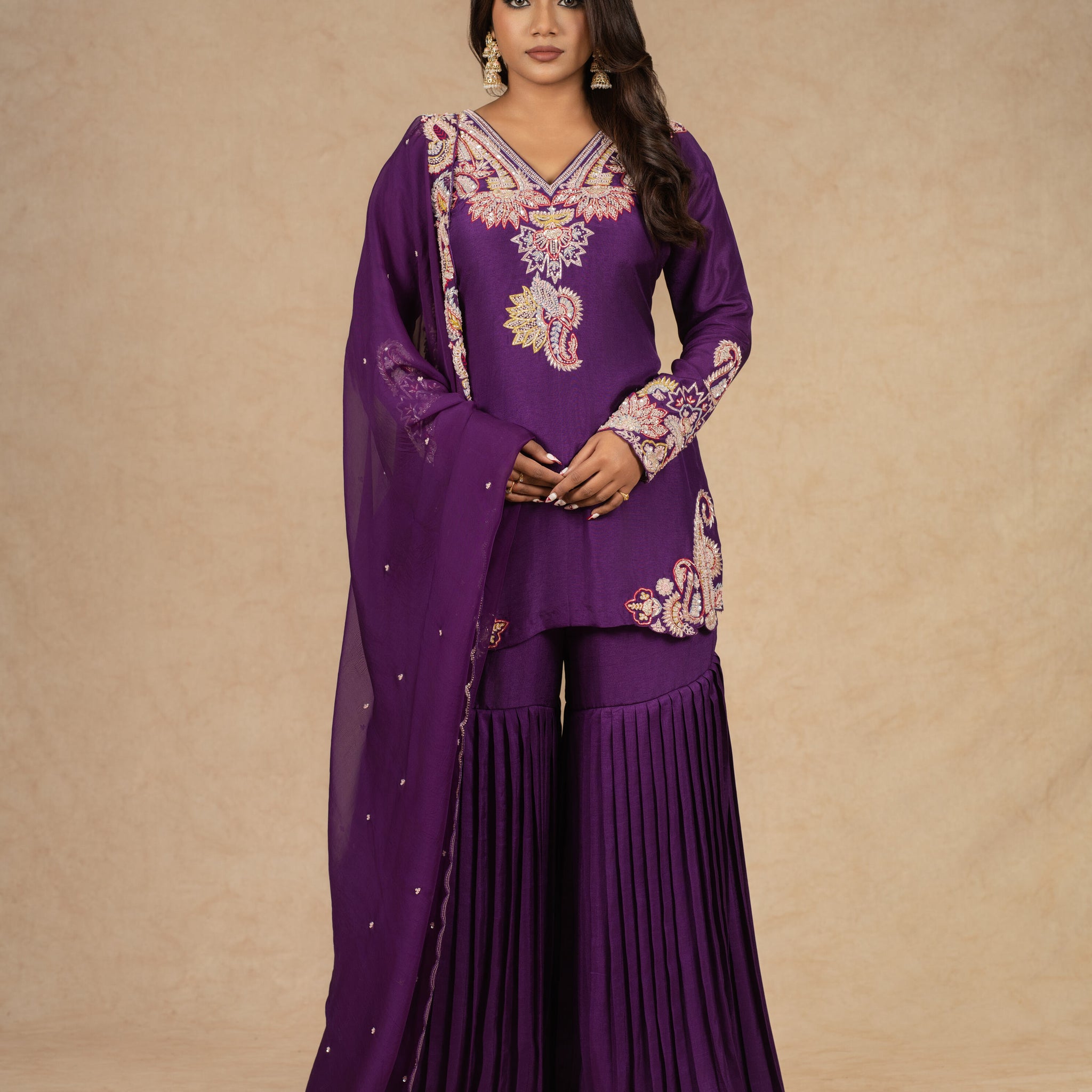 Elegant purple sharara suit with intricate dabka, kasab, sequins, thread, and pitai work, paired with an organza dupatta, ideal for festive and wedding occasions.