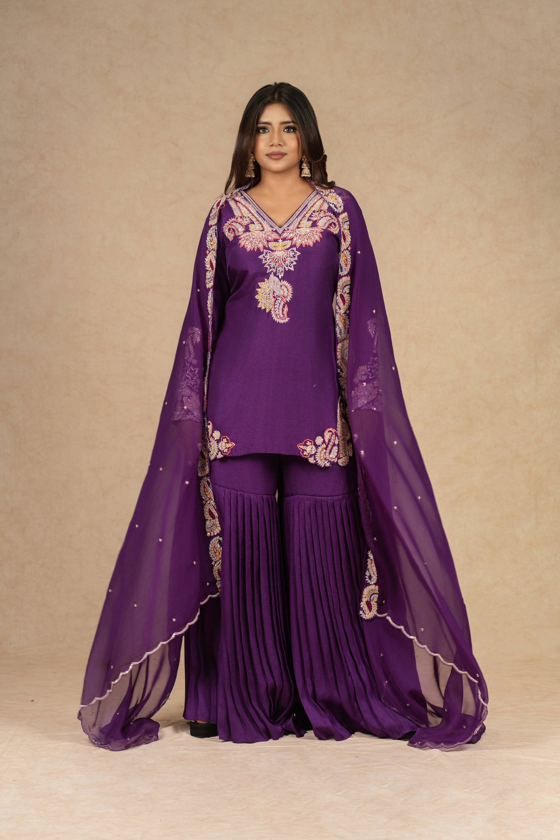 Elegant purple sharara suit with intricate dabka, kasab, sequins, thread, and pitai work, paired with an organza dupatta, ideal for festive and wedding occasions.