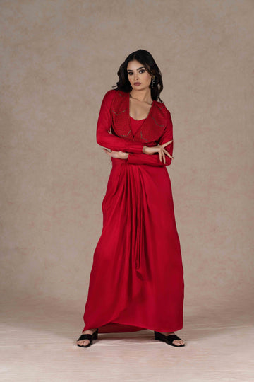 Red Indo-western three-piece set with an embroidered lapel collar jacket, sequined bustier, and draped skirt, blending tradition with modern elegance.